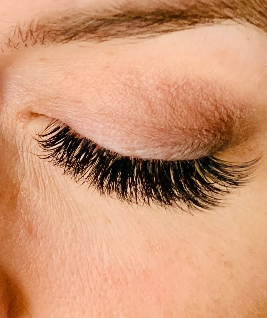 Nahaufnahme eines Auges mit dichter, geschwungener Wimpernverlängerung